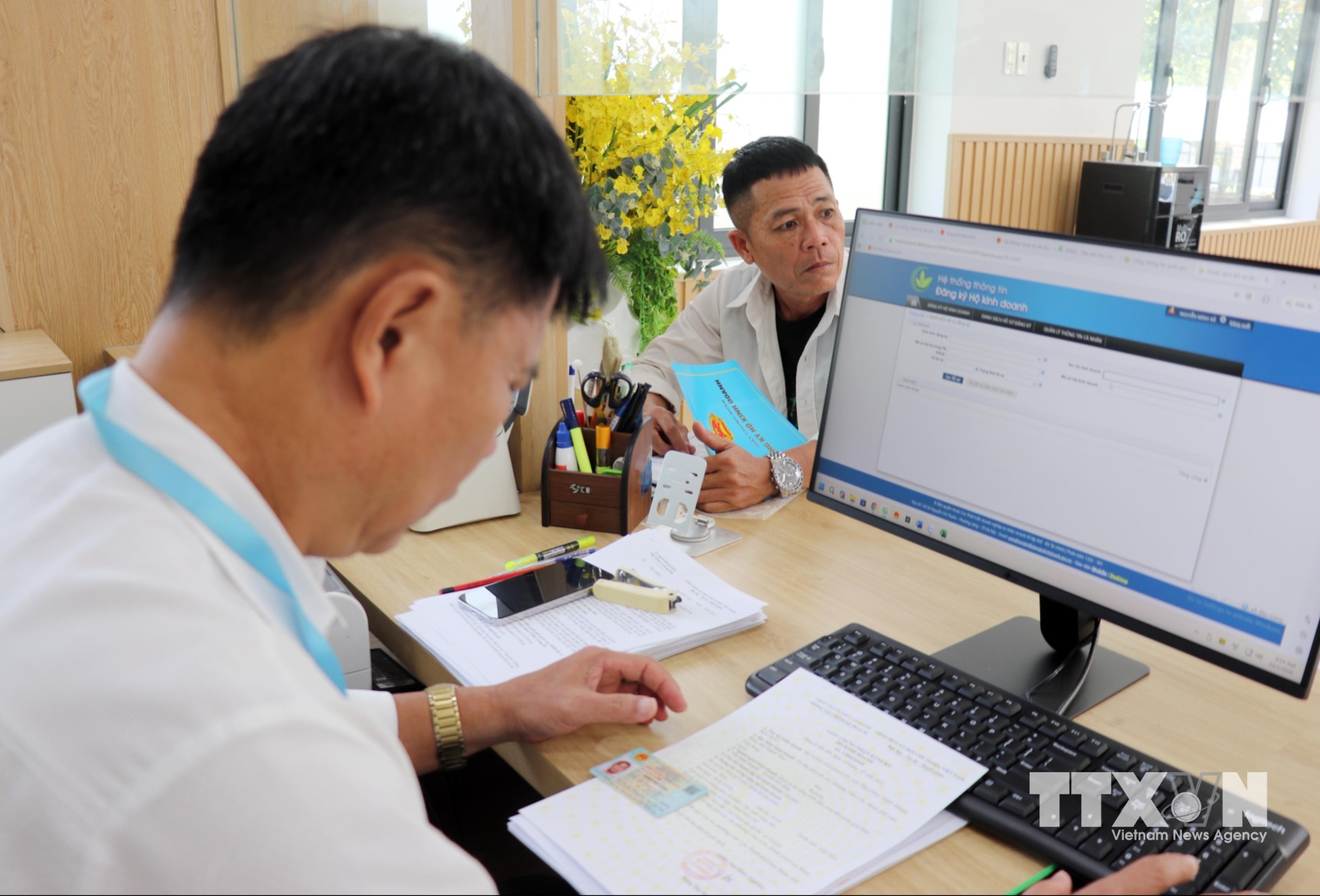 Cán bộ Trung tâm Phục vụ hành chính công phường Cam Ranh xử lý hồ sơ về đất đai cho người dân. (Ảnh: Công Thử/TTXVN)